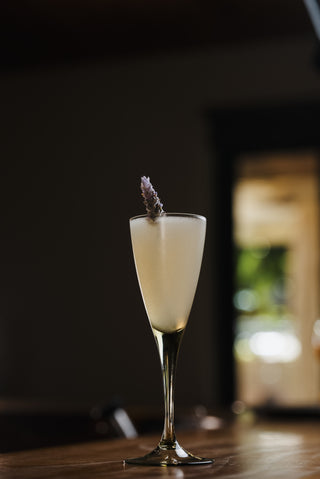 Jeremy pushed a Katinka cocktail across the wooden bar, a lavender sprig garnishes