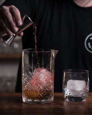 Whiskey and Campari poured into mixing jug