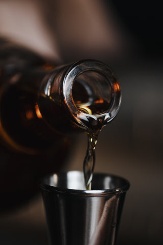 Whiskey poured into a jigger