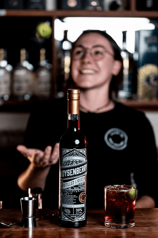 Boysenberry Liqueur with Isabella tossing a lime in the background