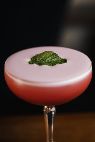 Boysenberry Sour garnish of mint leave in pink cocktail