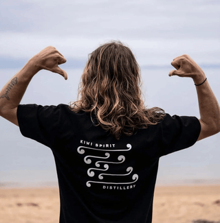 Joe at the beach with a Kiwi Spirit Distillery T-shirt