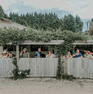 Kiwi Spirits Cellar Door outside seating area, happy customers drinking in the shade