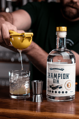 Championz Gin with a squeeze of lemon being added to a cocktail