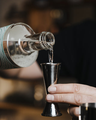 Delightful Dry Martini pouring delightful gin into the jigger