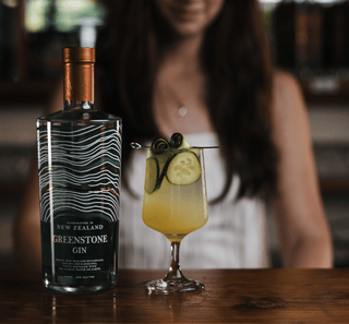 Greenstone New Zealand Gin pictured on a wooden bar with Homemade Lemonade with person in the background