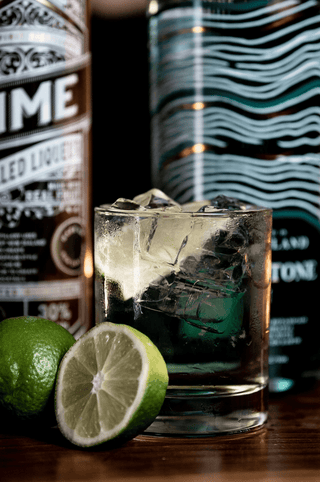 Lime Liqueur close up of label and a lime and soda cocktail
