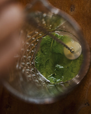 Muddle lime and mint leaves for the Tangelo Smash