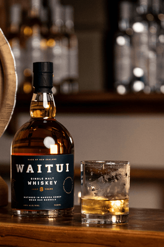 Waitui New Zealand Whiskey Bottle with mini barrel and glass of Whiskey 