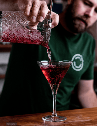 Jeremy pouring Collingwood Cranberry out of a cocktail jug into a martini glass, bright red cocktail made with vodka