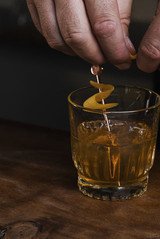 Amber Honey on wooden bar with lemon twist