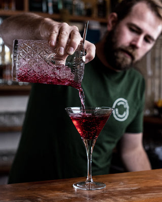 Jeremy pouring Collingwood Cranberry out of a cocktail jug into a martini glass, bright red cocktail made with vodka