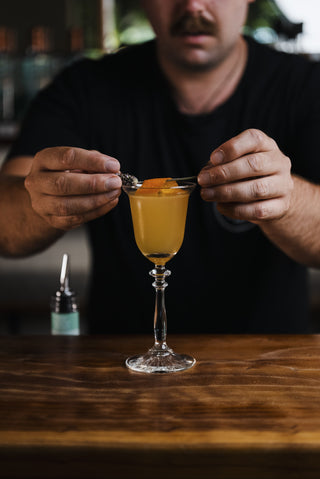 Placing the garnish on the mayfair cocktail