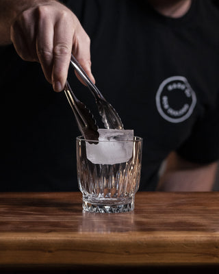 Large ice cube placed into glass