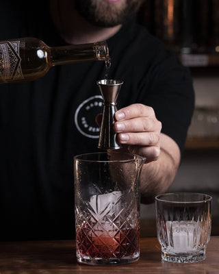 Lime Liqueur poured into mixing glass for Negroni cocktail