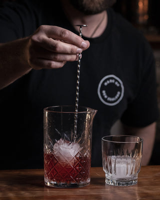 Stirring the Negroni cocktail on the bar