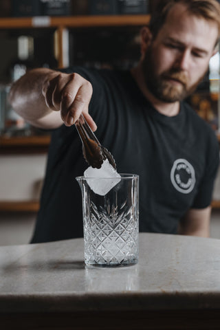 Putting large square ice cube into glass