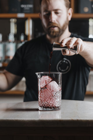 Spring Punch boysenberry liqueur poured over large ice cube