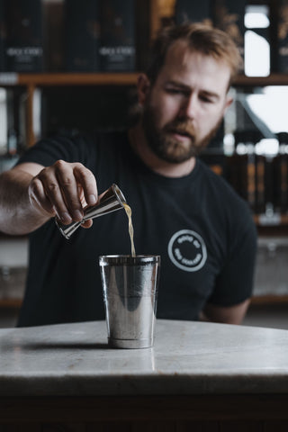 Jeremy pouring spirits into shaker