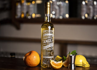 Tangelo Liqueur with fresh Tangelos on a wooden bar