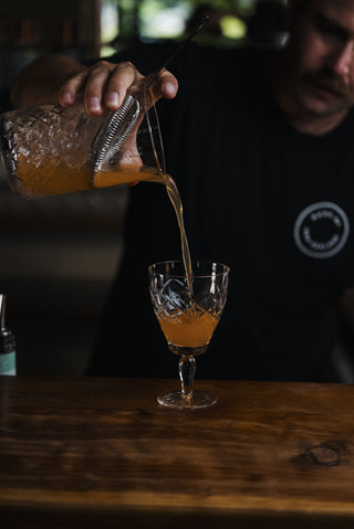 The Bridesmaid poured into goblet glass on wooden bar