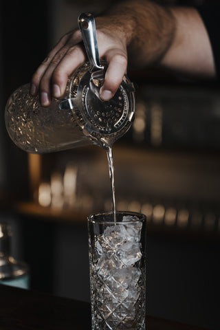 Pouring the Tom Collins into tall glass