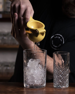 Lemon squeezed into mixing glass for the Tom Collins